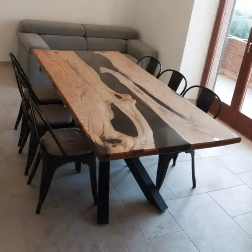 Tavolo in legno massello con inserto in resina grigia e struttura in metallo in sala da pranzo